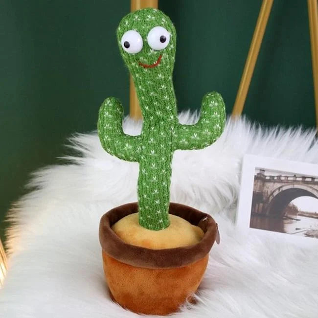 Plush cactus toy with googly eyes and a smile in a pot on a white surface.