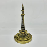 Bronze-colored model of minar e pakistan on a white background