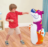 Child playing with a colorful inflatable punching bag shaped like a cat in a room.