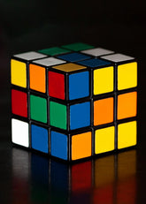 Rubik's Cube with colored squares on a reflective surface