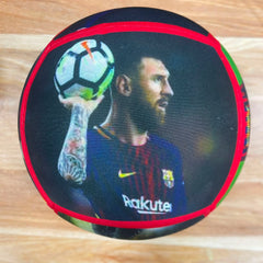 A round black cushion featuring a printed graphic of Lionel Messi in an FC Barcelona jersey holding a soccer ball, with a red border and green accents, placed on a light wood floor.