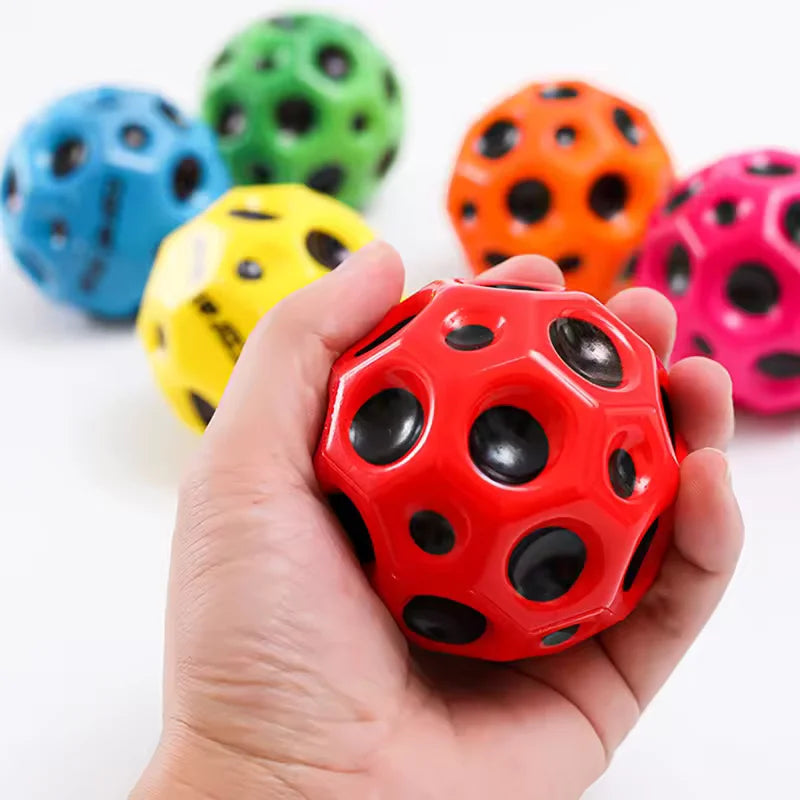 Colorful textured balls with a hand holding a red one against a white background