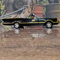 Model of a black Batmobile on a wooden surface with a blurred background