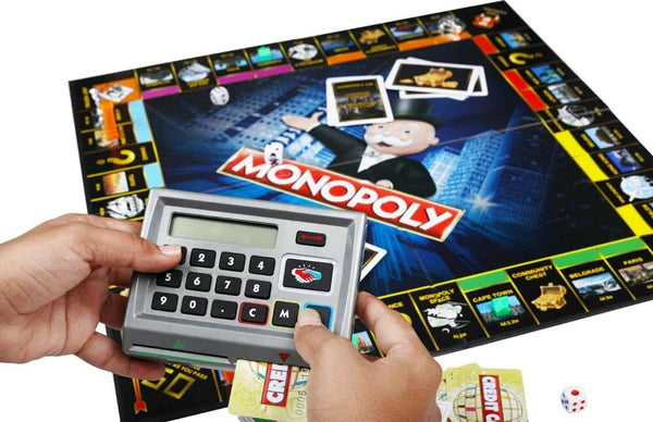 Monopoly board game with electronic device and cards on a white background
